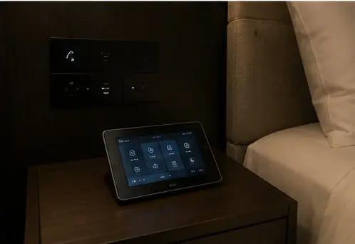 A control tablet on a bedside table in a guest room